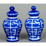 A pair of Peking overlay blue and white glass vases Each of ovoid form with removable lid.