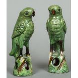 A pair of Chinese pottery models of parrots Each formed standing on a pierced base.