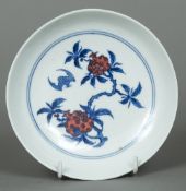 A Chinese porcelain dish The interior decorated with a bat amongst fruiting stems,