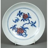 A Chinese porcelain dish The interior decorated with a bat amongst fruiting stems,