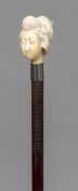 A 19th century wooden shafted walking stick The ivory handle carved as the bust of a Japanese woman.