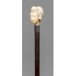 A 19th century wooden shafted walking stick The ivory handle carved as the bust of a Japanese woman.