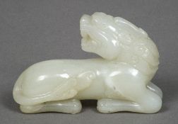 A Chinese carved celadon jade temple lion Worked in recumbent pose. 8.5 cm long.