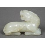 A Chinese carved celadon jade temple lion Worked in recumbent pose. 8.5 cm long.