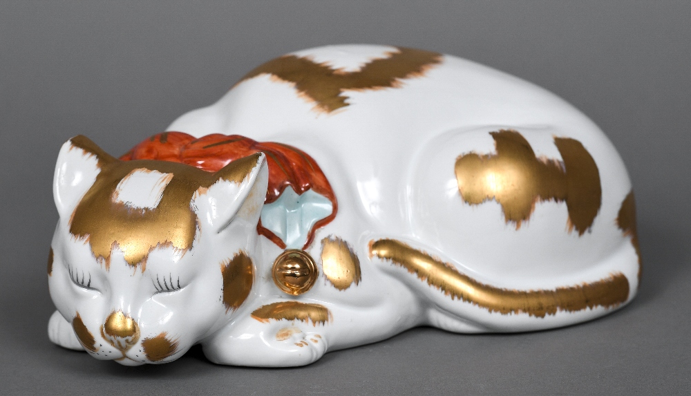 A large Japanese Kutani porcelain model of a recumbent cat Naturalistically modelled wearing a