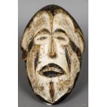 A carved softwood tribal mask With open eyes and mouth and with painted decorations. 28.5 cm high.