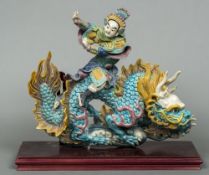 A Chinese pottery figural group Modelled as a male figure in flowing robes and a headdress riding a