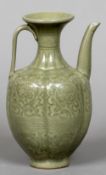 A Chinese celadon ground wine ewer Decorated in the round with scrolling foliage. 20 cm high.