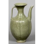 A Chinese celadon ground wine ewer Decorated in the round with scrolling foliage. 20 cm high.