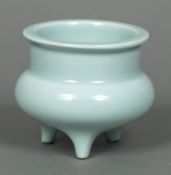 A small Chinese celadon ground censor Of typical squat circular form with three short legs,