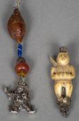 Two Chinese pendants One worked as a white metal mounted carved ivory figure,