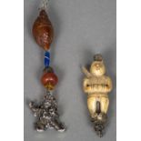 Two Chinese pendants One worked as a white metal mounted carved ivory figure,