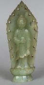 A Chinese carved green jade figure Modelled standing before a flaming Mandorla. 22.5 cm high.