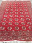 A Tekke wool carpet The wine red field enclosing five rows of nine guls interspersed with