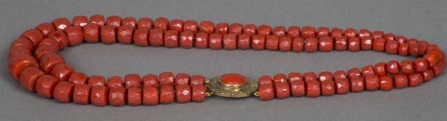 A two string facet cut coral bead necklace Set with a coral mounted 18 K gold clasp.