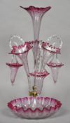 A Victorian clear and cranberry glass epergne Each trumpet vase interspersed with a spiral moulded