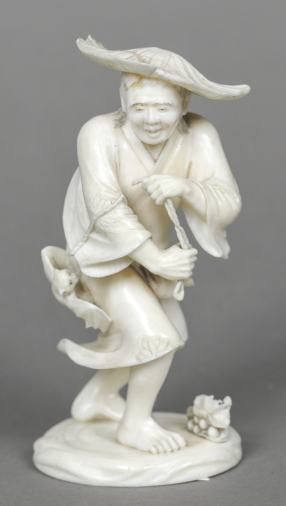 A late 19th/early 20th century Japanese carved ivory okimono Worked as a bat catcher. 12.5 cm high.
