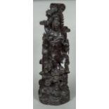 A large Chinese hardwood carving of Guanyin Modelled standing next to an attendant,