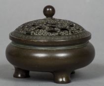 A small Chinese patinated bronze censor The pierced removable lid above the squat rounded body with