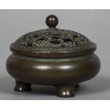 A small Chinese patinated bronze censor The pierced removable lid above the squat rounded body with