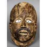 A softwood tribal mask Set with glass eyes and traces of original paint. 30 cm high.