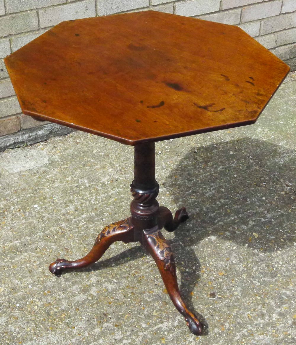 A George III mahogany tilt top tripod table The octagonal top above the carved and turned column,