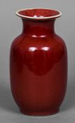 A Chinese sang de boeuf vase The flared neck rim above the plain ovoid body,