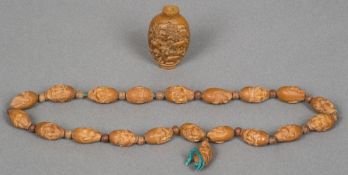 A Chinese string of carved beads Modelled as heads with various expression;