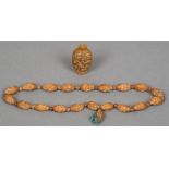 A Chinese string of carved beads Modelled as heads with various expression;