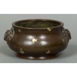 A Chinese patinated bronze and gold splash censor Of typical squat form with twin mask handles,