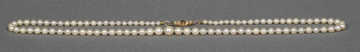 A pearl necklace Set with a garnet and seed pearl mounted 9 ct gold clasp. 49 cm long.