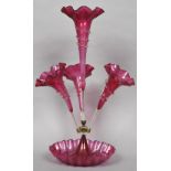 A Victorian cranberry glass epergne Of typical form, the base with wavy rim. 59.5 cm high.