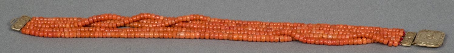 A five strand coral bead necklace Set with an engraved gold clasp. 37 cm long.