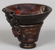 A Chinese carved horn libation cup With shallow bowl and mythical beast carvings,