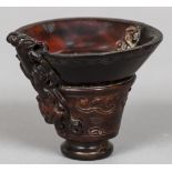 A Chinese carved horn libation cup With shallow bowl and mythical beast carvings,