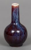 A small Chinese flambe glazed vase With elongated neck above the ovoid body,