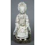 A Chinese Song dynasty part celadon glazed blanc de chine porcelain figure of Guanyin Typically