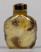 A Chinese carved shadow agate snuff bottle and stopper Worked with monkeys and birds in a tree,