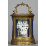 A late 19th century miniature oval gilt brass carriage clock Decorated with Sevres style painted