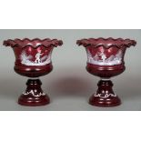 A pair of Mary Gregory cranberry glass pedestal bowls Each with wavy rim and decorated with a child