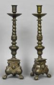 A pair of 17th century style patinated bronze candlesticks Each with a wide dished drip pan above