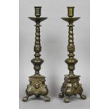 A pair of 17th century style patinated bronze candlesticks Each with a wide dished drip pan above