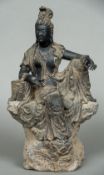 A large Chinese carving of Guanyin Modelled seated in open robes leaning on a stack of books. 46.