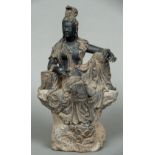 A large Chinese carving of Guanyin Modelled seated in open robes leaning on a stack of books. 46.