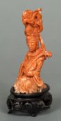 A Chinese carved coral figure of Guanyin Modelled seated holding a mandolin and wearing a headdress,