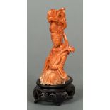 A Chinese carved coral figure of Guanyin Modelled seated holding a mandolin and wearing a headdress,