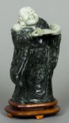 A carved jade figure of Buddha Modelled standing holding an open scroll,