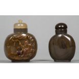 Two Chinese carved agate snuff bottles and stoppers The larger worked with a sage.