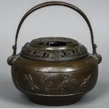 A 19th century Chinese bronze censor With swing loop handle above the pierced removable cover,