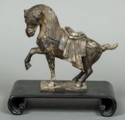 A Chinese cast metal Tang style horse Typically modelled, standing on a scrolling hardwood base.